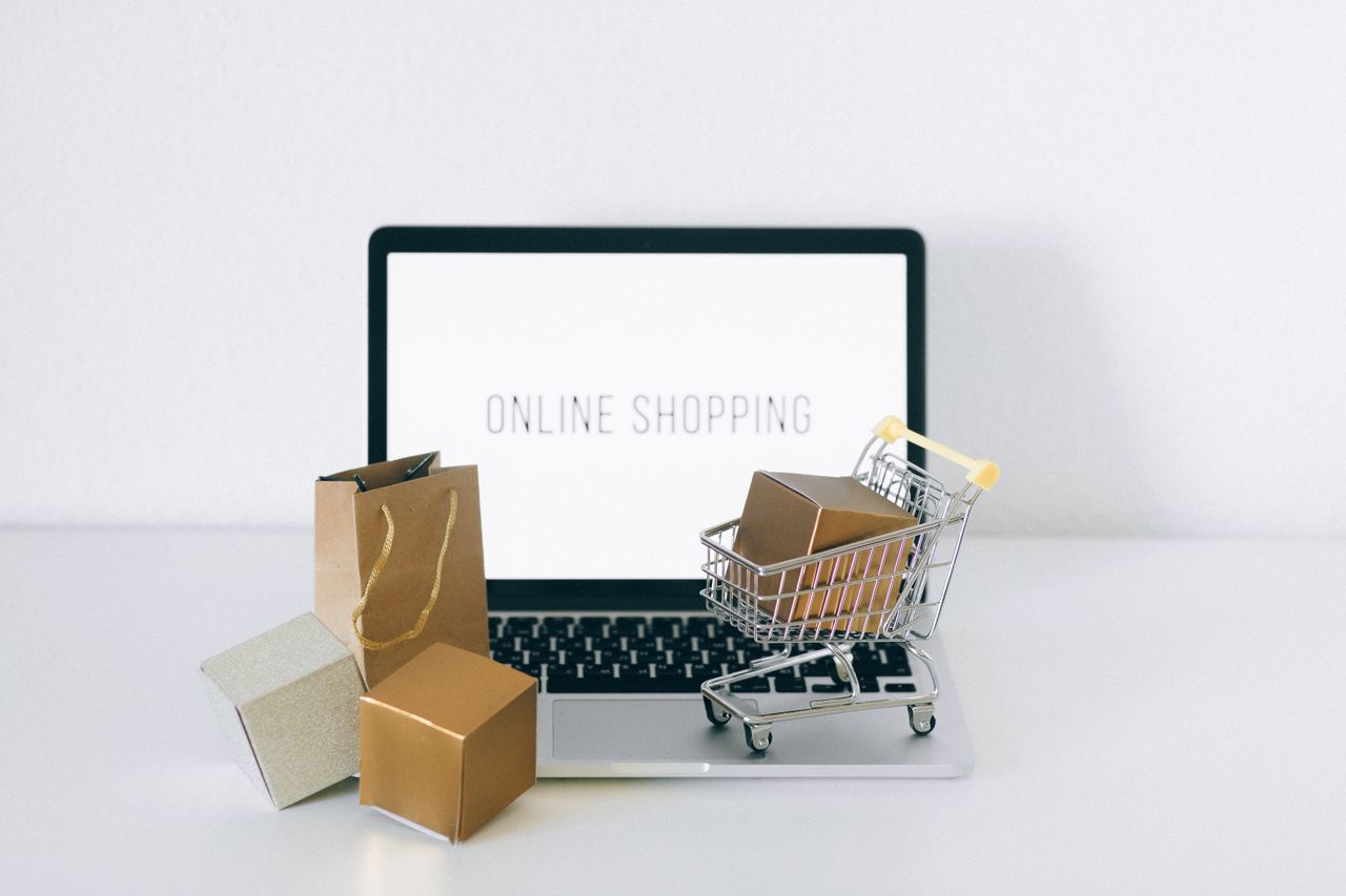 services-01 Laptop displaying online shopping with boxes and cart, representing ecommerce.